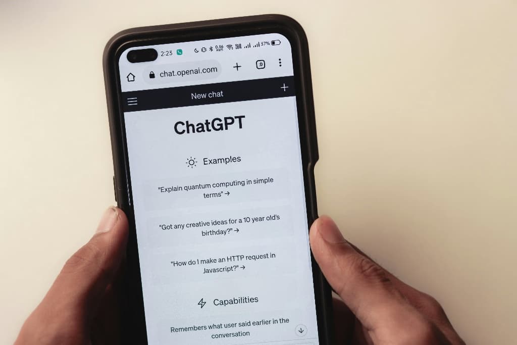 Persoon houdt smartphone vast met ChatGPT open in de browser